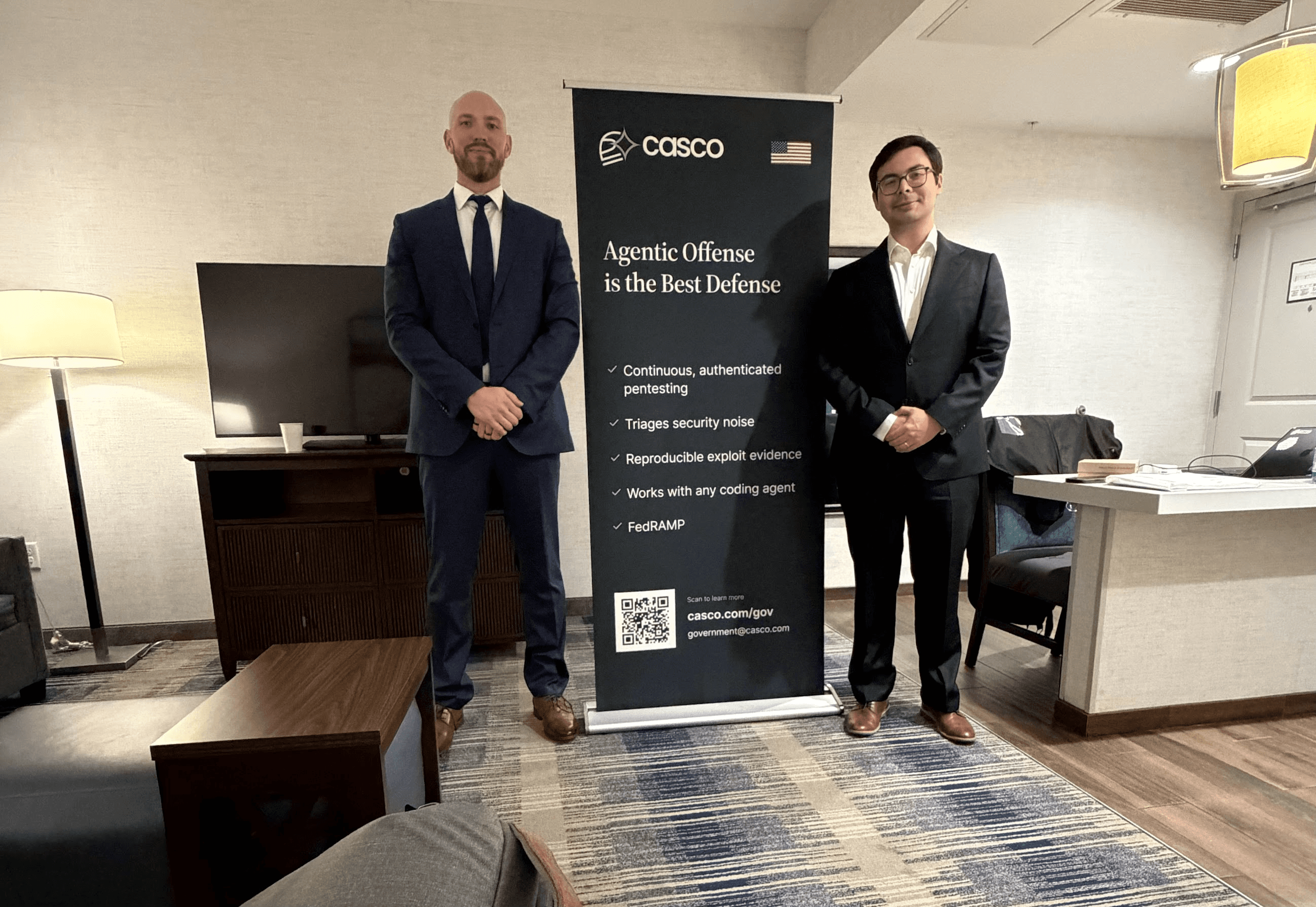 The Casco team practicing for the Pentagon meeting beside a Casco banner at the hotel